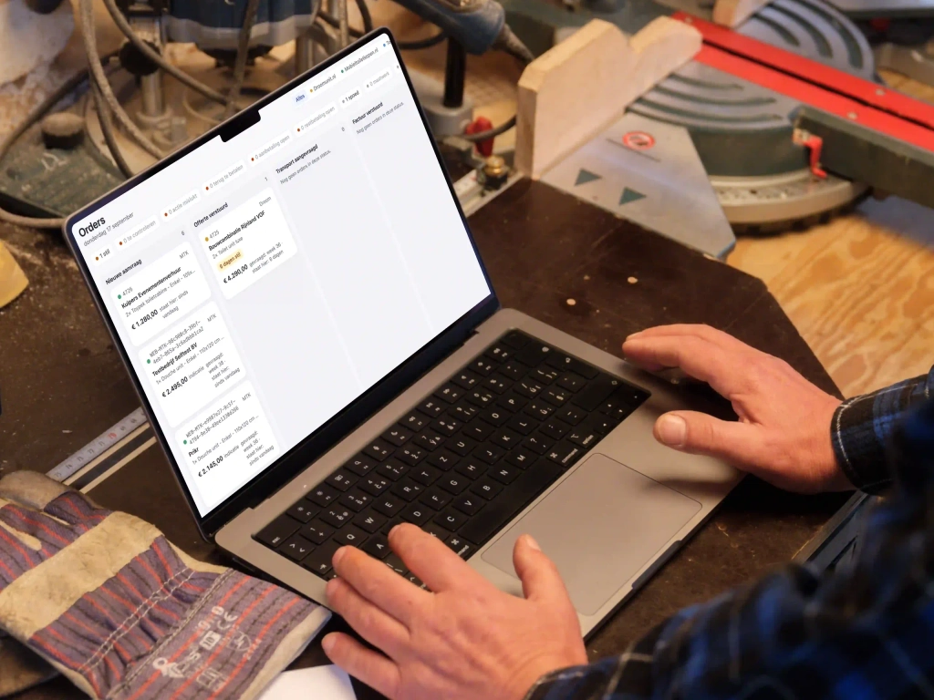 Medewerker bekijkt orders van Astronau op een laptop in de werkplaats