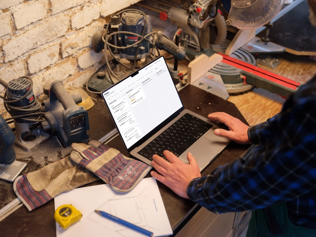 Medewerker bekijkt orders van Astronau op een laptop in de werkplaats
