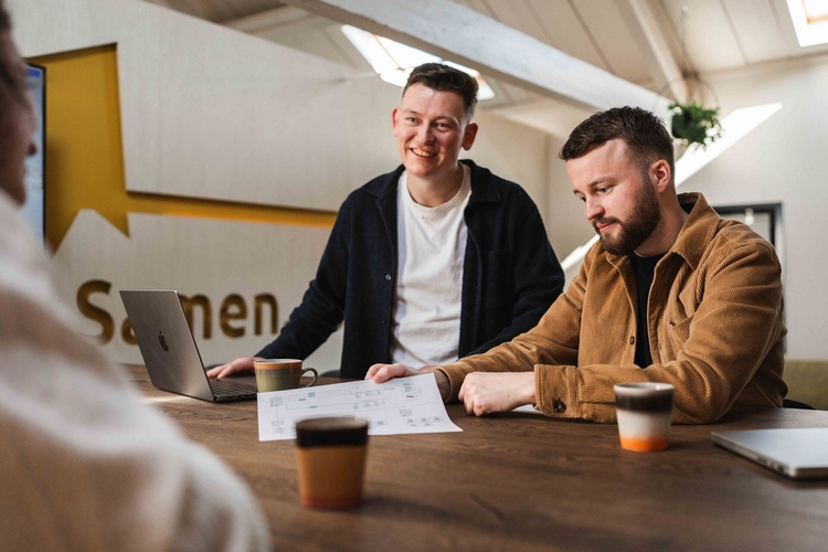 Twee collega's overleggen bij een laptop over software voor de groothandel