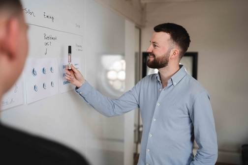 Plan op papier wordt doorgenomen aan tafel, ontwerp van voorraadbeheer software op maat