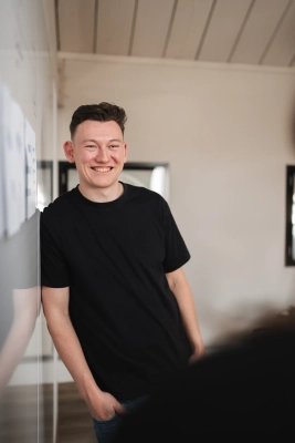 Software specialist van Prikr die leunt tegen een whiteboard.