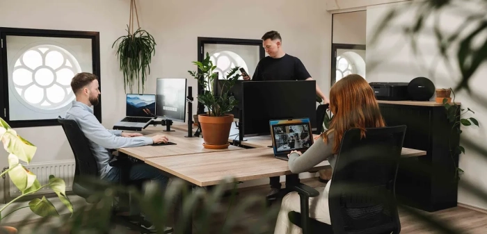 Het team werkt op kantoor aan het ontwerp voor een maatwerk website laten maken.