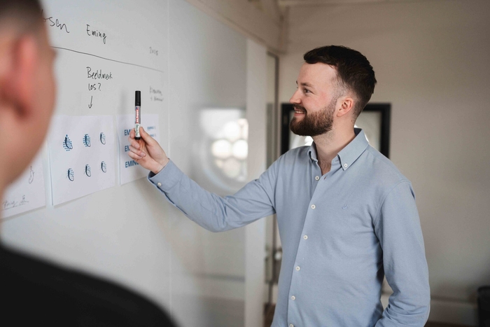 Plan op papier wordt doorgenomen aan tafel, ontwerp van voorraadbeheer software op maat