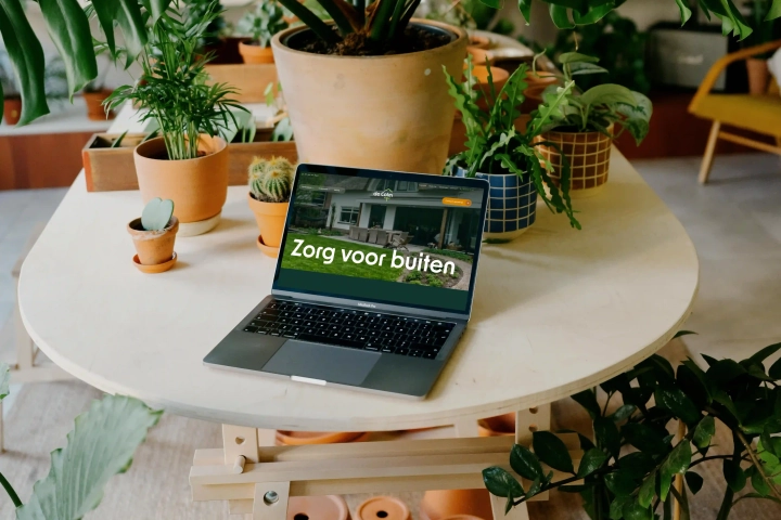 Website vernieuwen voor hoveniersbedrijf De Colm, de nieuwe site op een laptop tussen planten