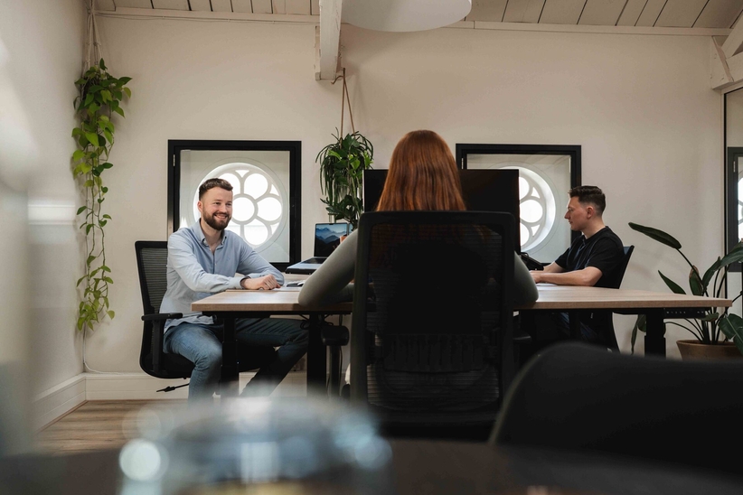 Team bekijkt bedrijfsnieuws op een scherm, sociaal intranet voor medewerkers
