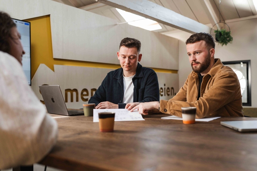 Twee collega's bekijken de orderstatus op een dashboard, ordermanagement op maat voor het MKB