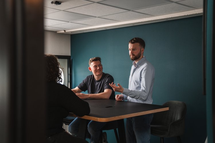 Team van Prikr bespreekt de webapplicatie-roadmap met KPI-dashboard op scherm